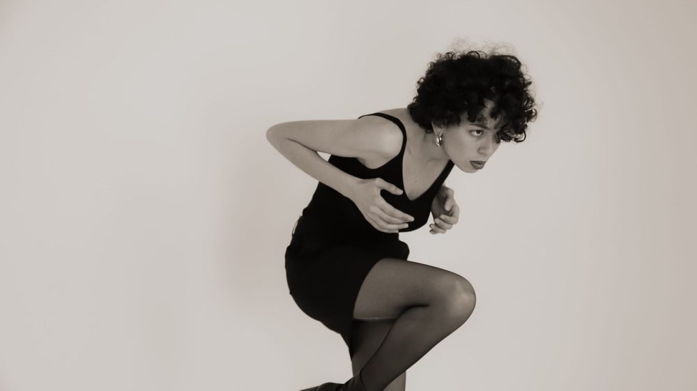Asmae Fegnaoui in motion — black-and-white studio portrait